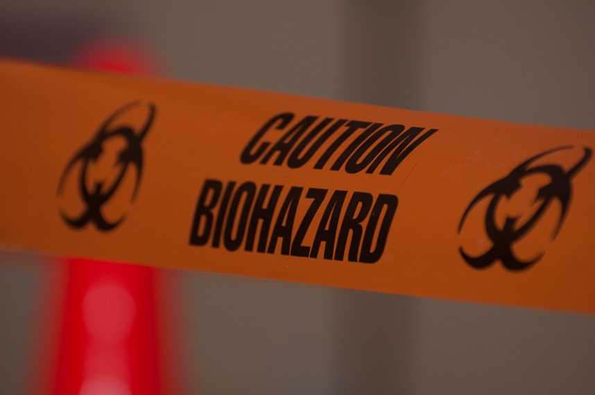 Orange caution tape warns of a biohazard clean up site
