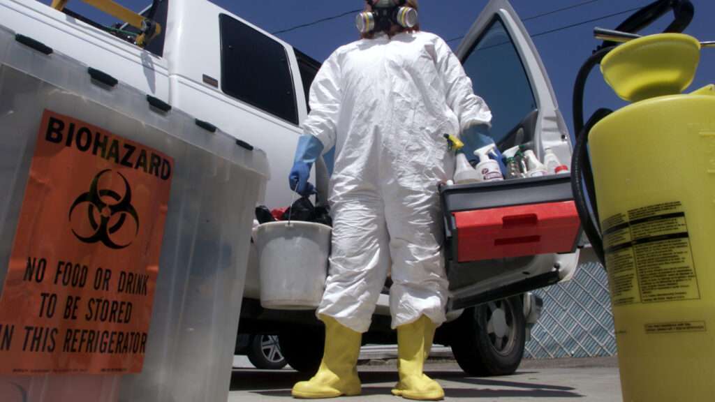 Biohazard cleanup specialist disinfecting contaminated crime scene